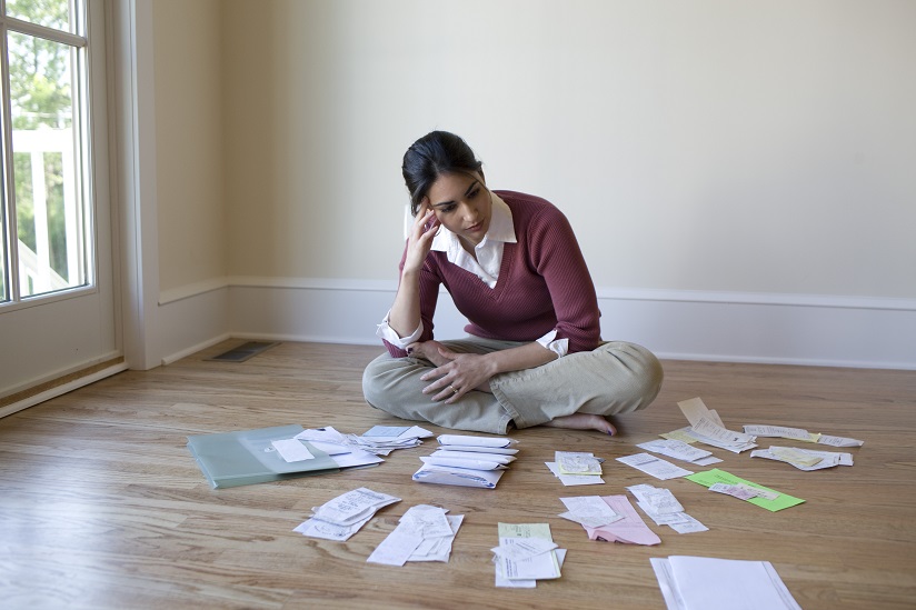 Woman sitting on the floor surrounded by paperwork 