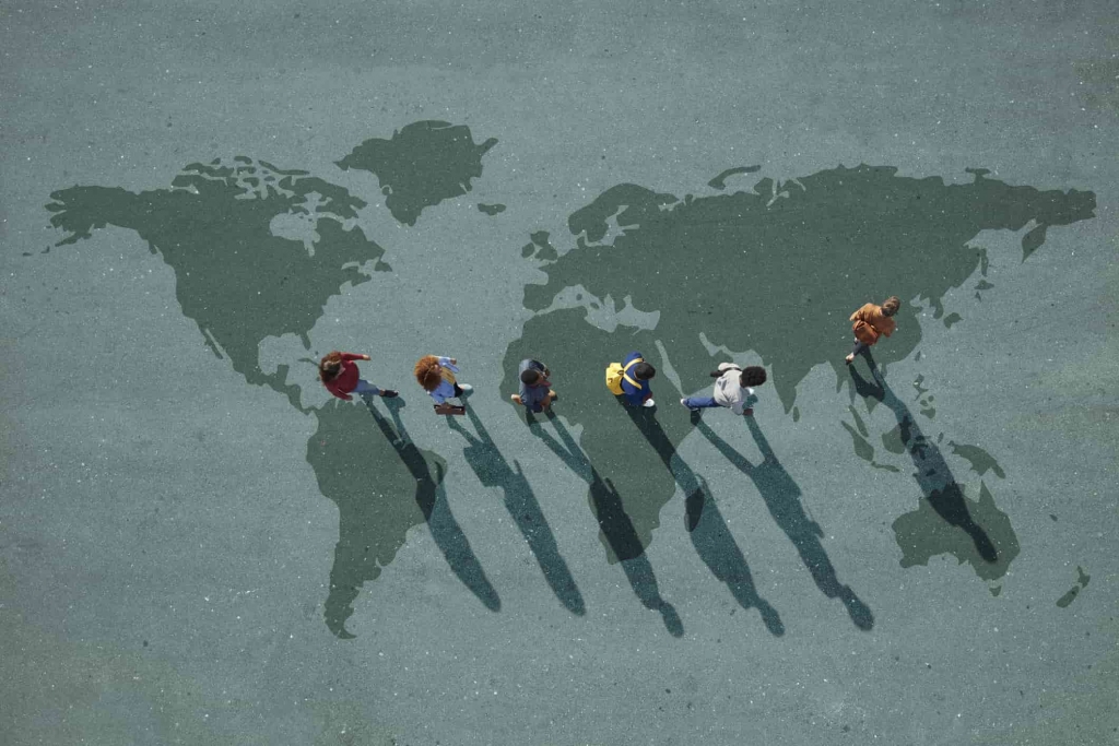 세계 지도 위를 걷고 있는 한 무리의 사람들